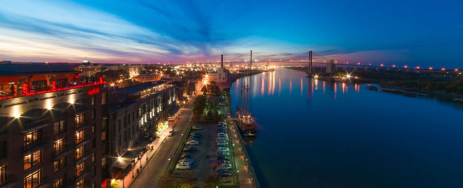 Evening view of River Street in Savannah\'s Historic District with twinkling lights reflecting off the Savannah River